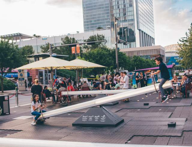Children On a Seesaw At The Impulse Sneak Preview Event In Houston, TX